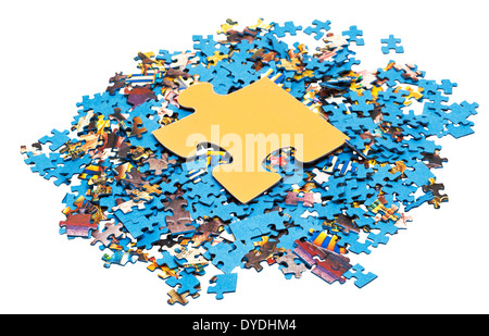 große gelbe Einteiler auf Haufen von zerlegten kleine blaue Puzzles isoliert auf weißem Hintergrund Stockfoto