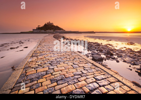 Der Damm führt zu St. Michaels Mount in Cornwall, England bei Ebbe, fotografiert bei Sonnenuntergang Stockfoto