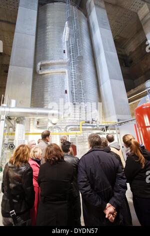 Hamburg, Deutschland. 11. März 2014. Mitglieder einer Gruppe Besucher stehen vor einem Wärmespeicher in der Energiebunker in Hamburg, Deutschland, 11. März 2014. Denn Demontage der ehemaligen Bunkerb zu teuer wäre, wurde es in einem lokalen Kraftwerk für erneuerbare Energien umgewandelt. Die Energie-Bunker (Deutsch: Energiebunker) im Hamburger Stadtteil Wilhelmsburg ist ein weltweit einzigartiges Konzept. Foto: Bodo Marks/Dpa/Alamy Live News Stockfoto