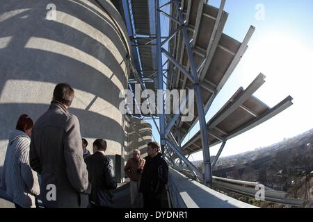 Hamburg, Deutschland. 11. März 2014. Besucher gehen vorbei an Module einer Photovoltaikanlage auf dem Energie-Bunker (Deutsch: Energiebunker) in Hamburg, Deutschland, 11. März 2014. Weil Demontage des ehemaligen Bunkers zu teuer gewesen wäre, wurde es in einem lokalen Kraftwerk für erneuerbare Energien umgewandelt. Der Energie-Bunker im Hamburger Stadtteil Wilhelmsburg ist ein weltweit einzigartiges Konzept. Foto: Bodo Marks/Dpa/Alamy Live News Stockfoto