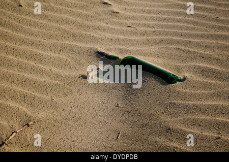 Verlassene Flasche Wein, die Hälfte in den Sand am 90 Mile Beach, Whangarei Neuseeland begraben. Stockfoto