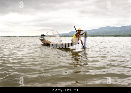 Fisher Mann am Inle-See, der größte Süßwasser-See in Birma. Er nutzt ein Netz und auch eine konische Fischfalle. Stockfoto