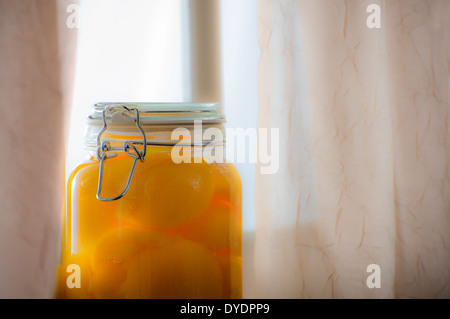 Dose Pfirsiche durch Fenster Stockfoto