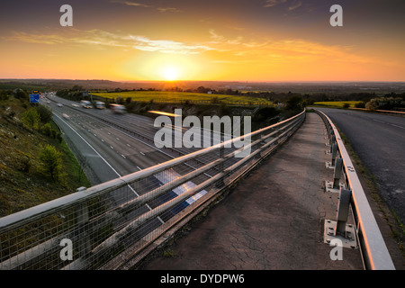 Die Sonne geht über der Stadt von Swindon Wiltshire während der Rush Hour Traffic beginnt, Licht zu malen entlang der Autobahn M4 Wanderwege. Stockfoto