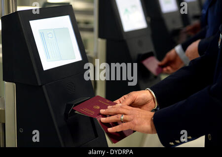 Düsseldorf, Deutschland. 15. April 2014. Ein Mann hält seinen Pass über ein Lesegerät der neuen Grenze Kontrollsystems EasyPass am Flughafen Düsseldorf, Deutschland, 15. April 2014 abgebildet sind. EasyPass ist Testlauf in Düsseldorf und prüft die Dokumente der Reisenden. Foto: Matthias Balk/Dpa/Alamy Live News Stockfoto