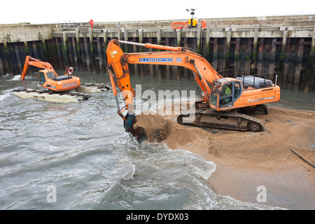 Baggerarbeiten Vorgänge um den Hafen nach den Winterstürmen an der West Bay, Bridport, Dorset UK zu löschen Stockfoto