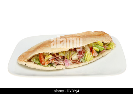 Fladenbrot gefüllt mit knusprigem Speck und Salat auf einem Teller isoliert gegen weiß Stockfoto
