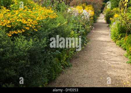 Einen Gartenweg Anfang September gesäumt von Staudenrabatten mit Spätsommer blühenden Pflanzen, Rousham House, Oxfordshire, England Stockfoto