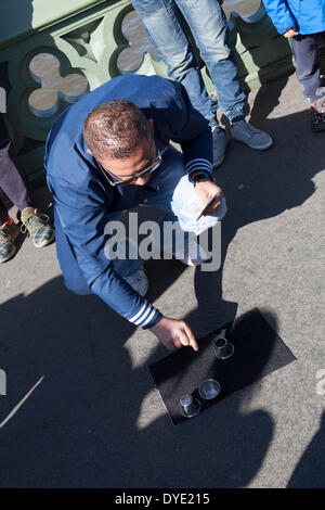 Ein Hütchenspiel Praktiker auch bekannt als Thimblerig, drei Muscheln und eine Erbse Glücksspiel mit Urlaub Menschenmassen auf Westminster Bridge, London. Stockfoto