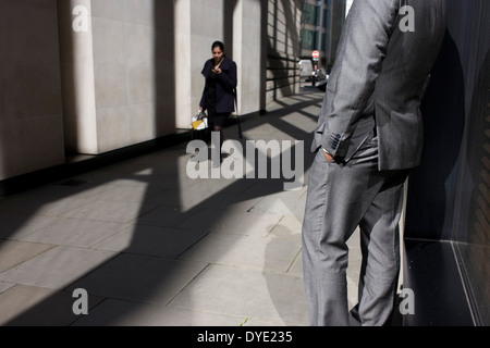 Anonyme Mann glänzend grauen Anzug steht in sonnigen Gasse in der City of London. Stockfoto