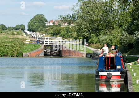 Ein Narrowboat vertäut am unteren Rand der Flug der Verriegelungen auf dem Kennet & Avon Kanal in Caen Hill in der Nähe von Devizes, Wiltshire, UK Stockfoto