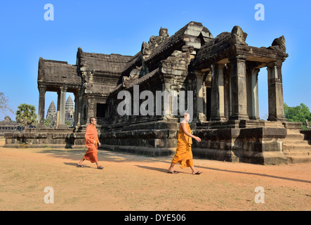 Zwei besuchende Mönche flanieren über den Innenhof vor der North Library, Angkor Wat mit den fünf Türmen von Angkor Wat dahinter, Kambodscha, Südostasien Stockfoto