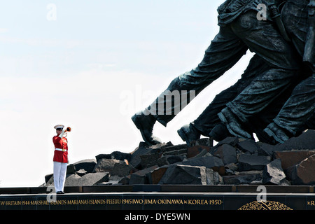 US Marine Corps Staff Sgt Codie Williams spielt die Trompete in der Nähe von den riesigen Füßen des Marine Corps War Memorial während einer Trauerfeier für pensionierte General Carl E. Mundy Jr., der 30. Kommandant des Marinekorps 12. April 2014 in Arlington, Virginia. Stockfoto