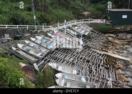 Eine Gruppe von kleinen Booten, die über der Flut-Linie im Gordons Bay Fishing Club in der Nähe von Coogee, Australien, gezogen wurden. Das Hotel liegt am Coogee zu Bondi Küstenweg. Stockfoto