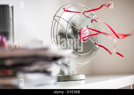 Eine alte grüne Tischventilator mit roten Bändern vor einem weißen Hintergrund Stockfoto