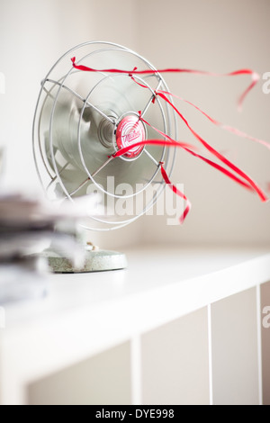 Eine alte grüne Tischventilator mit roten Bändern vor einem weißen Hintergrund Stockfoto