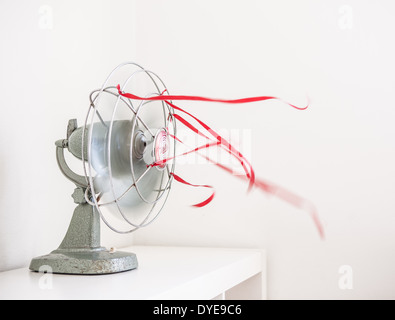 Eine alte grüne Tischventilator mit roten Bändern vor einem weißen Hintergrund Stockfoto