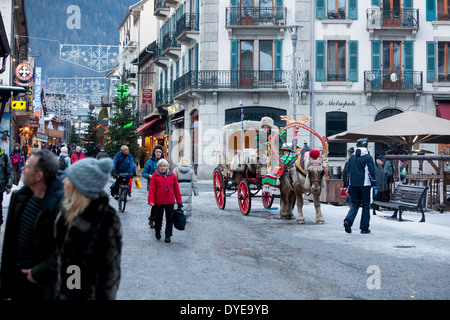 Fußgänger gehen vorbei an einem Pferd gezogenen Buggy in Fell an der Rue du Docteur Paccard im Dorf Chamonix Mont-Blanc abgedeckt. Stockfoto