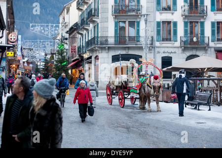 Fußgänger gehen vorbei an einem Pferd gezogenen Buggy in Fell an der Rue du Docteur Paccard im Dorf Chamonix Mont-Blanc abgedeckt. Stockfoto