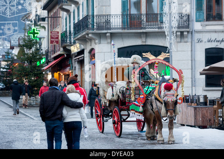 Fußgänger gehen vorbei an einem Pferd gezogenen Buggy in Fell an der Rue du Docteur Paccard im Dorf Chamonix Mont-Blanc abgedeckt. Stockfoto