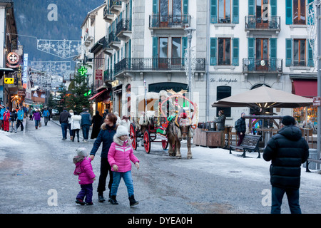 Fußgänger gehen vorbei an einem Pferd gezogenen Buggy in Fell an der Rue du Docteur Paccard im Dorf Chamonix Mont-Blanc abgedeckt. Stockfoto