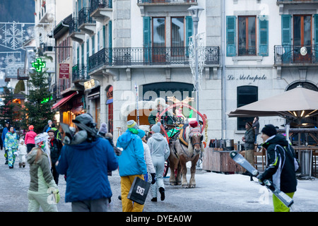 Fußgänger gehen vorbei an einem Pferd gezogenen Buggy in Fell an der Rue du Docteur Paccard im Dorf Chamonix Mont-Blanc abgedeckt. Stockfoto