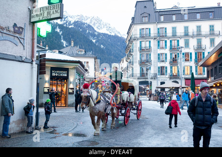 Fußgänger gehen vorbei an einem Pferd gezogenen Buggy in Fell an der Rue du Docteur Paccard im Dorf Chamonix Mont-Blanc abgedeckt. Stockfoto