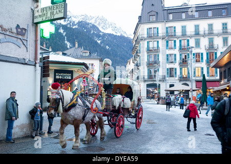 Fußgänger gehen vorbei an einem Pferd gezogenen Buggy in Fell an der Rue du Docteur Paccard im Dorf Chamonix Mont-Blanc abgedeckt. Stockfoto