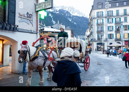 Fußgänger gehen vorbei an einem Pferd gezogenen Buggy in Fell an der Rue du Docteur Paccard im Dorf Chamonix Mont-Blanc abgedeckt. Stockfoto