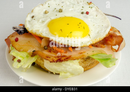 Burger mit Spiegeleiern und Speck-Salat Stockfoto