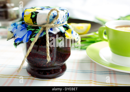 Hausgemachte, Himbeer Marmelade in ein Glas Marmelade. Tee und Schokolade auf dem Tisch. Stockfoto