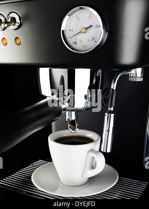 NAHAUFNAHME VON EINER FRISCH GEBRÜHTEN TASSE KAFFEE VORBEREITET MIT EINER ESPRESSO-MASCHINE Stockfoto