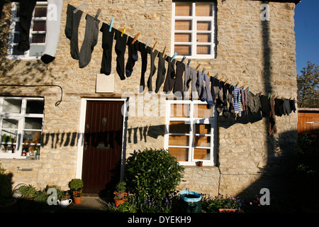 Eine Mischung aus verschiedenen Socken aufhängen und trocknen auf eine Wäscheleine draußen. Stockfoto