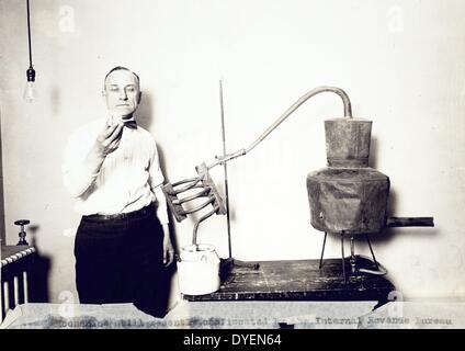 Moonshine noch vor kurzem durch die internen Erlöse Präsidium beschlagnahmt an der Abteilung Treasury zwischen 1921 und 1932 fotografiert. Mann stand neben noch Inhalt von Glas. Stockfoto