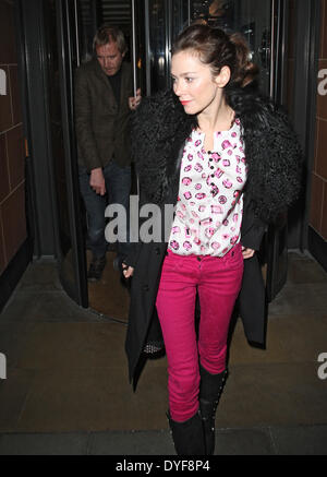 Paparazzi voller Länge roten Mantel Schauspielerin Lippenstift dunkle Haare braune Haare Stiefel Stockfoto