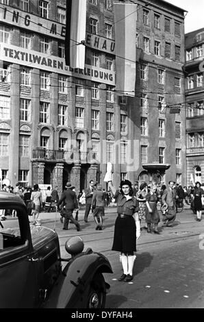 Ein Polizist regelt den Verkehr als eine Menge von Menschen besuchen die Herbst Expo im Ring-Messehaus Convention Center auf dem Troendlinring in Leipzig, Deutschland, 1948. Foto: Zbarchiv - NO-Draht-SERVICE Stockfoto