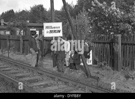 Berliner befestigen Sie ein Schild mit dem Abonnement "Welcome to Berlin" an der Route des Interzonenturnier Zuges im Mai 1949. Nach der Aufhebung der Berlin-Blockade am 12. Mai 1949, wurde der Bahnverkehr zwischen Berlin und den Westzonen wieder in Betrieb genommen. Stockfoto