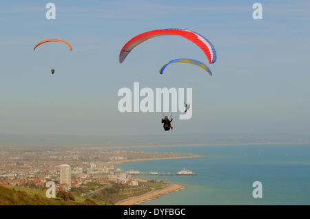 Beachy Head, Eastbourne, East Sussex, Großbritannien..16. April 2014..Gleitschirmflieger nutzen die steife Brise aus dem Süden über Eastbourne an der Sussex Coast. Stockfoto