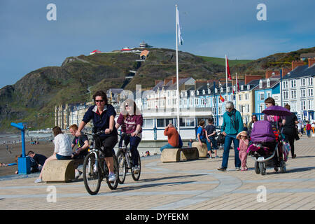 Aberystwyth, Wales, UK. 16. April 2014.   Menschen, die die Sonne am Strand und der Promenade in Aberystwyth zu Beginn des Osterfestes Ferienzeit zu genießen.   Die Temperatur im Westen Wales Resort erreicht die hohe Teens Celsius am späten Nachmittag. Der Wetterbericht wird trüber und nasser in den kommenden Tagen werden aber Erwärmung wieder vom Ostersonntag Bildnachweis: Keith Morris/Alamy Live-Nachrichten Stockfoto