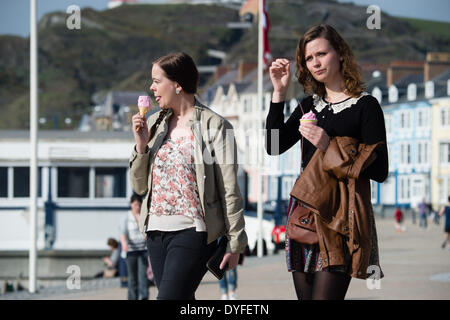 Aberystwyth, Wales, UK. 16. April 2014.   Zwei Frauen essen Eis die Sonne am Strand und der Promenade in Aberystwyth zu Beginn des Osterfestes Ferienzeit zu genießen.   Die Temperatur im Westen Wales Resort erreicht die hohe Teens Celsius am späten Nachmittag. Der Wetterbericht wird trüber und nasser in den kommenden Tagen werden aber Erwärmung wieder vom Ostersonntag Bildnachweis: Keith Morris/Alamy Live-Nachrichten Stockfoto