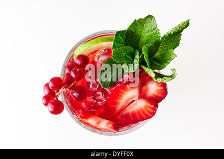 Gesunde rote Beeren cocktail mit Minze garnieren. Auf weißem Hintergrund. Ansicht von oben. Beeren sind Johannisbeeren, Erdbeeren und Kirschen. Stockfoto