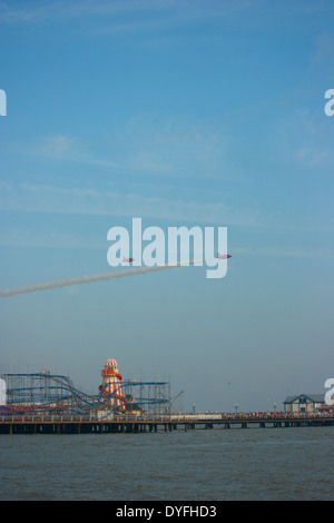 Zwei Red Arrows-Jets fliegen über Clacton Pier in Clacton Airshow, August 2013 Stockfoto