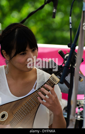 Mädchen spielen chinesisches Saiteninstrument am Faschingsdienstag, Bestandteil der Edinburgh Jazz und Blues Festival im Juli 2013. Stockfoto