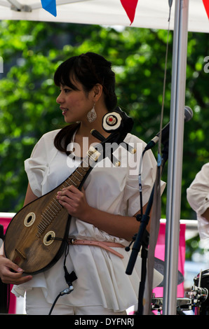 Mädchen spielen chinesisches Saiteninstrument am Faschingsdienstag, Bestandteil der Edinburgh Jazz und Blues Festival im Juli 2013. Stockfoto