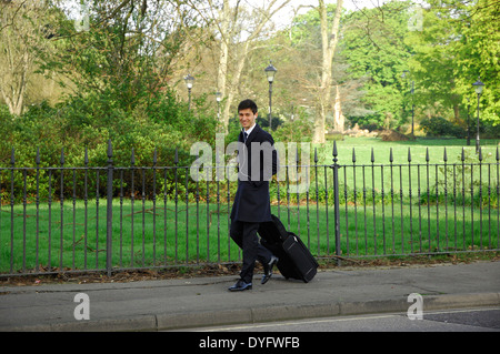 Elegant gekleidete Mann ziehen Gepäck in Southampton, England Stockfoto