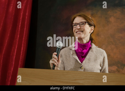 lächelnde Frau am Podium mit Mikrofon Stockfoto