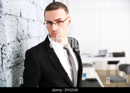 Zuversichtlich Geschäftsmann stand in der Nähe der Mauer Stockfoto