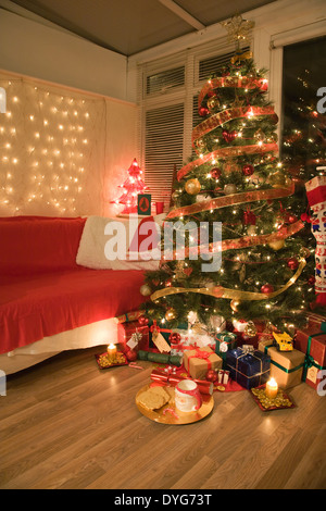 Geschenke unter einer beleuchteten Weihnachtsbaum Stockfoto