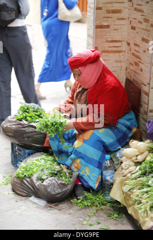 Frauen tragen traditionelle Kleidung auf einem Marktplatz in Tanger Marokko verkaufen Obst und Gemüse Stockfoto