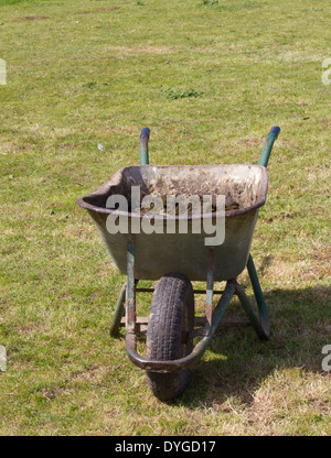 alt und abgenutzt Schubkarre ruht auf dem Rasen mit Pferdemist Stockfoto